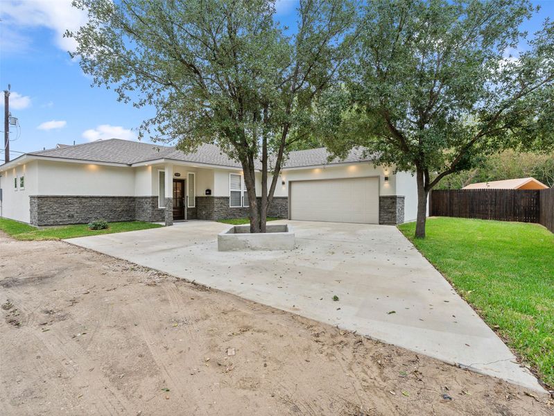 View of front of home with stone siding, stucco siding, concrete driveway, and a garage View of front of home with stone siding, stucco siding, concrete driveway, and a garage