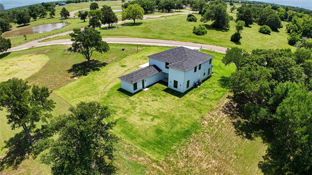View from above of property featuring a large body of water and a tree filled landscape