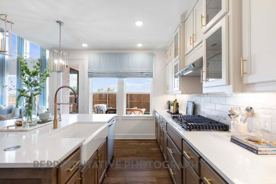 Kitchen featuring appliances with stainless steel finishes, dark wood-type flooring, light countertops, decorative backsplash, and white cabinets Kitchen featuring appliances with stainless steel finishes, dark wood-type flooring, light countertops, decorative backsplash, and white cabinets