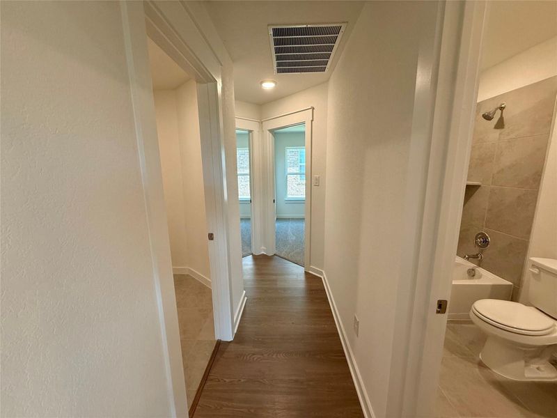 Hallway featuring baseboards and dark wood-type flooring Hallway featuring baseboards and dark wood-type flooring
