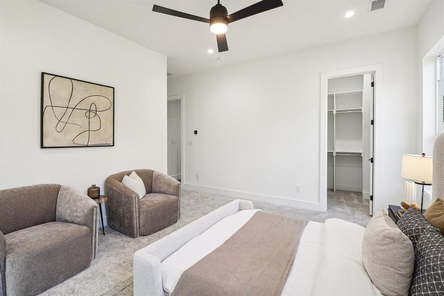 Bedroom with a spacious closet, light carpet, a closet, and ceiling fan