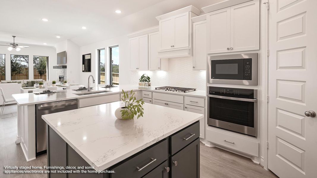 Kitchen featuring a center island, a peninsula, appliances with stainless steel finishes, recessed lighting, and white cabinetry Kitchen featuring a center island, a peninsula, appliances with stainless steel finishes, recessed lighting, and white cabinetry