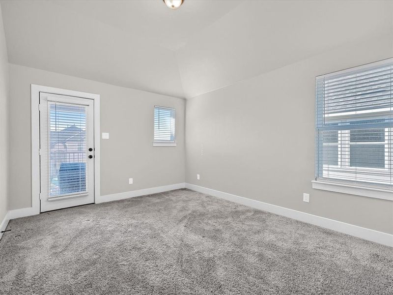 Empty room featuring lofted ceiling, a healthy amount of sunlight, and carpet Empty room featuring lofted ceiling, a healthy amount of sunlight, and carpet