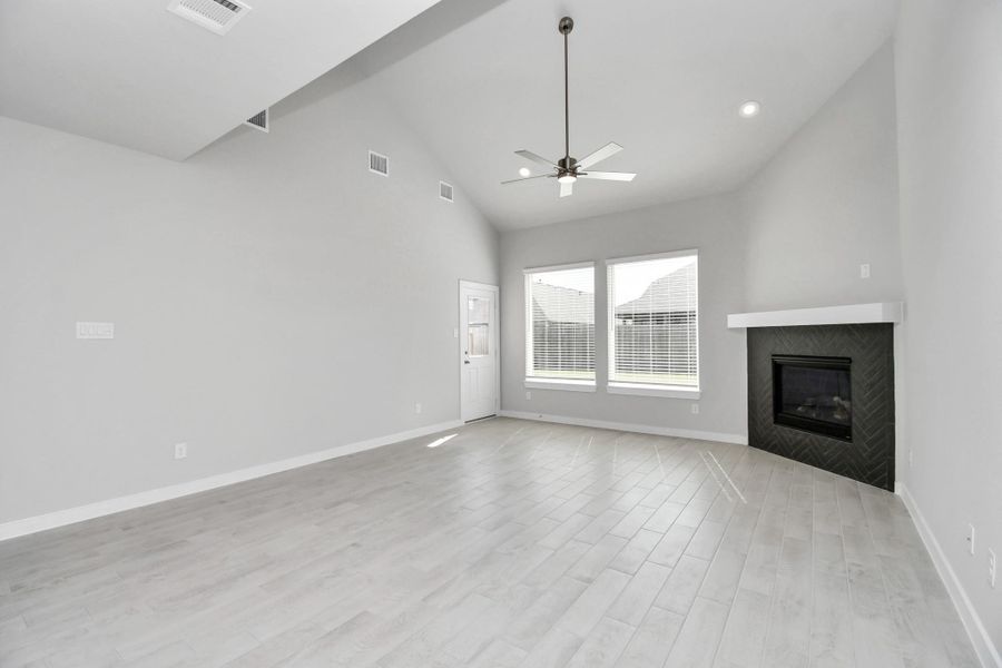 Gather the family and guests together in your lovely living room! Featuring soaring high ceilings, recessed lighting, ceiling fan, custom paint, gorgeous floors, and large windows that provide plenty of natural lighting throughout the day. Sample photo of completed home with similar floor plan. Actual colors and selections may vary.