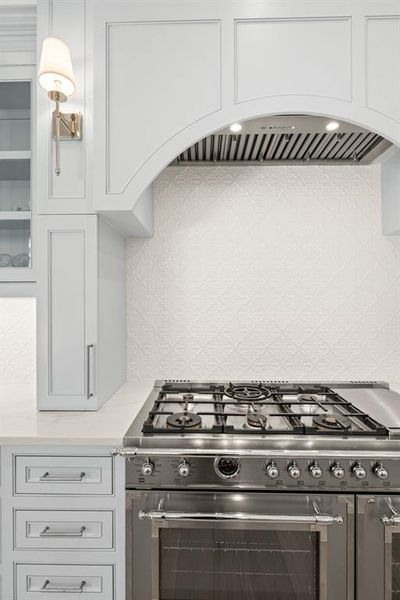 Kitchen featuring stainless steel range, light countertops, and white cabinetry Kitchen featuring stainless steel range, light countertops, and white cabinetry