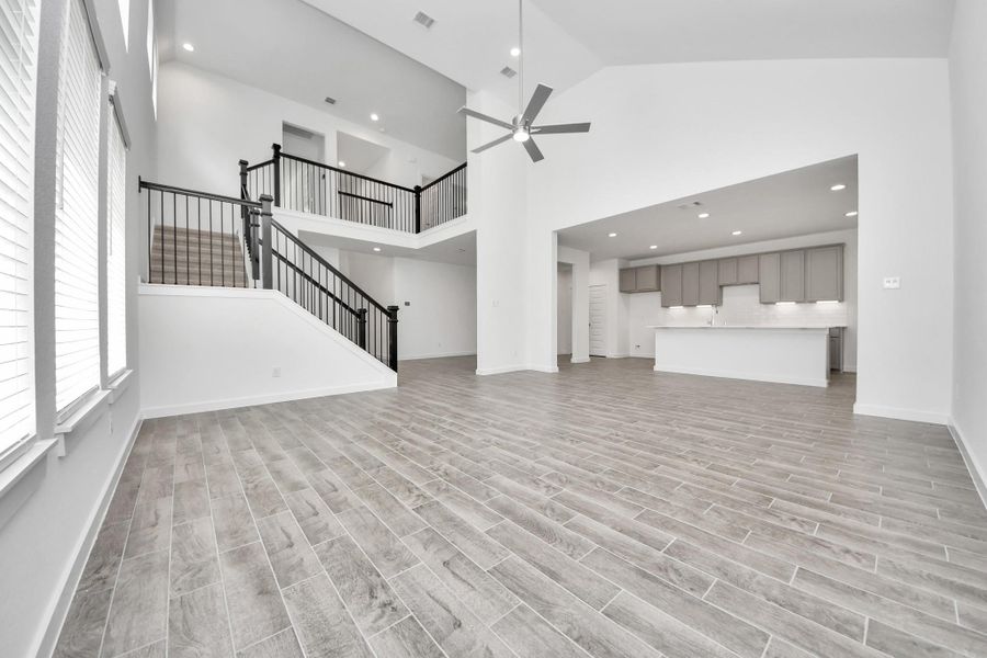 Relax and unwind in this inviting family room, illuminated by abundant natural light streaming in through tall windows, complemented by high ceilings and stunning flooring. Stay comfortable year-round with the gentle breeze from the ceiling fan, creating the perfect atmosphere for family gatherings. Sample photo of completed home with similar floor plan. Actual colors and selections may vary. Relax and unwind in this inviting family room, illuminated by abundant natural light streaming in through tall windows, complemented by high ceilings and stunning flooring. Stay comfortable year-round with the gentle breeze from the ceiling fan, creating the perfect atmosphere for family gatherings. Sample photo of completed home with similar floor plan. Actual colors and selections may vary.