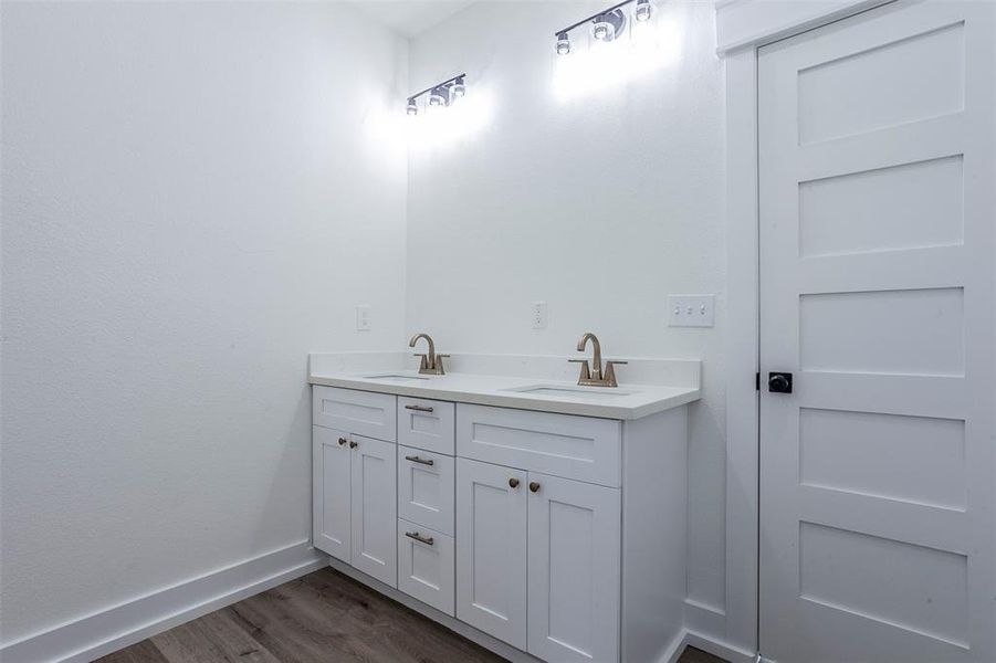 Double vanity with white cabinetry, light-toned countertops, and brushed nickel faucets