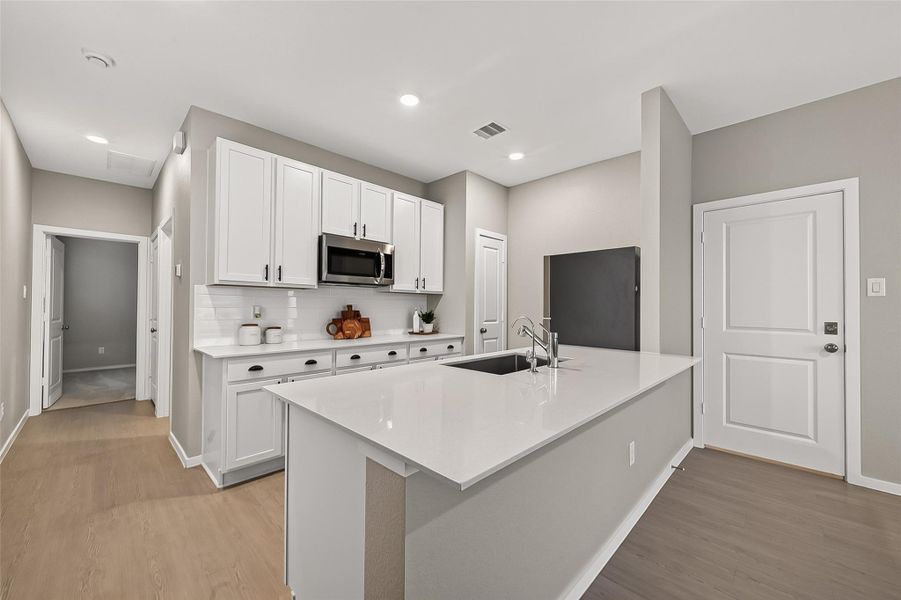 Guest suite kitchen featuring a large center island, abundant cabinetry, and recessed lighting. Guest suite kitchen featuring a large center island, abundant cabinetry, and recessed lighting.