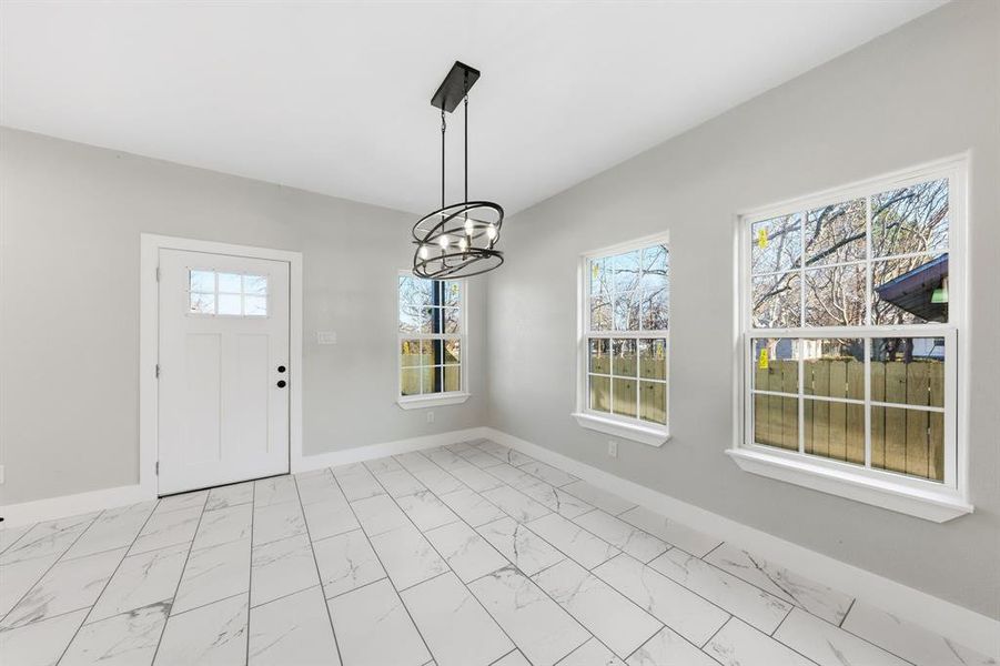 Foyer featuring a chandelier and light marble finish floors