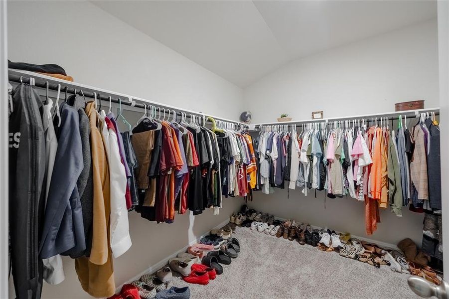 Spacious closet featuring vaulted ceiling and carpet flooring
