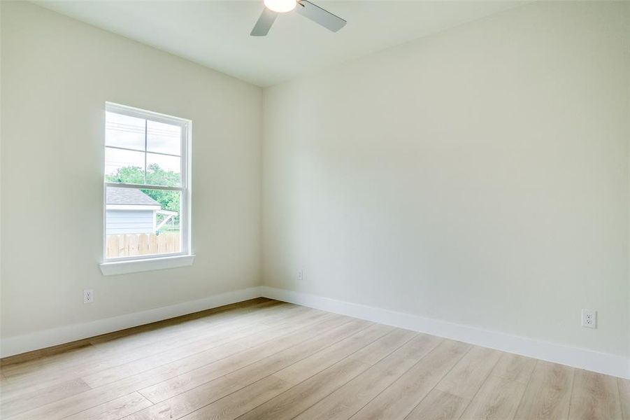 Empty room featuring baseboards, ceiling fan, and wood finished floors