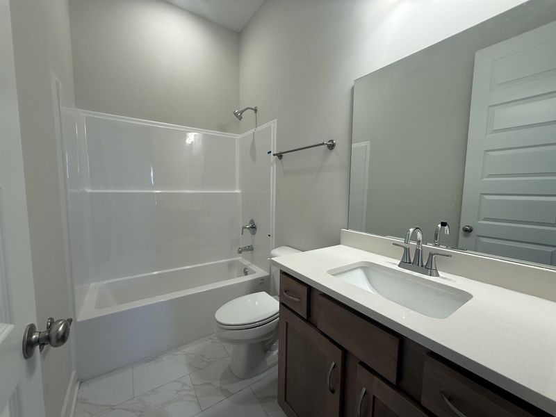 Full bathroom with vanity, bathtub / shower combination, and light marble finish flooring