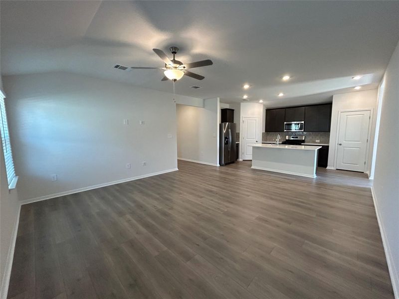 Unfurnished living room featuring dark wood-type flooring, ceiling fan, and recessed lighting Unfurnished living room featuring dark wood-type flooring, ceiling fan, and recessed lighting
