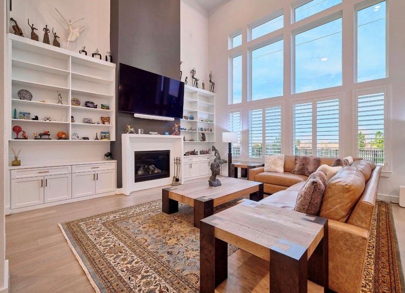 Your stunning living room features high ceilings, expansive windows, a sleek gas fireplace, and custom cabinetry, all with breathtaking views.