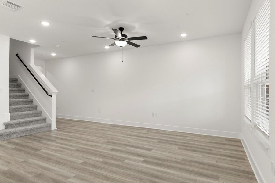 Unfurnished living room with recessed lighting, light wood-style floors, stairs, and a ceiling fan