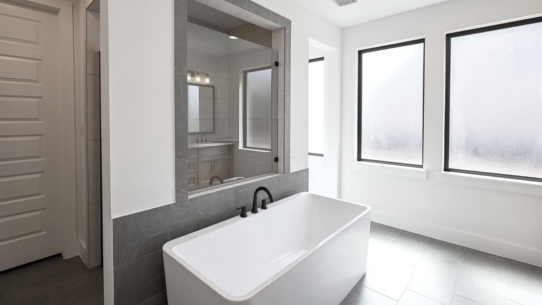 Bathroom with a freestanding tub, tile walls, and tile patterned flooring Bathroom with a freestanding tub, tile walls, and tile patterned flooring