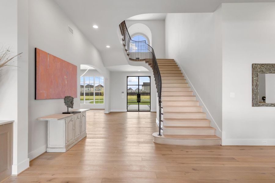 View straight into the grand entry foyer with sweeping stair case. The formal dining is the left through the curved arch. View straight into the grand entry foyer with sweeping stair case. The formal dining is the left through the curved arch.