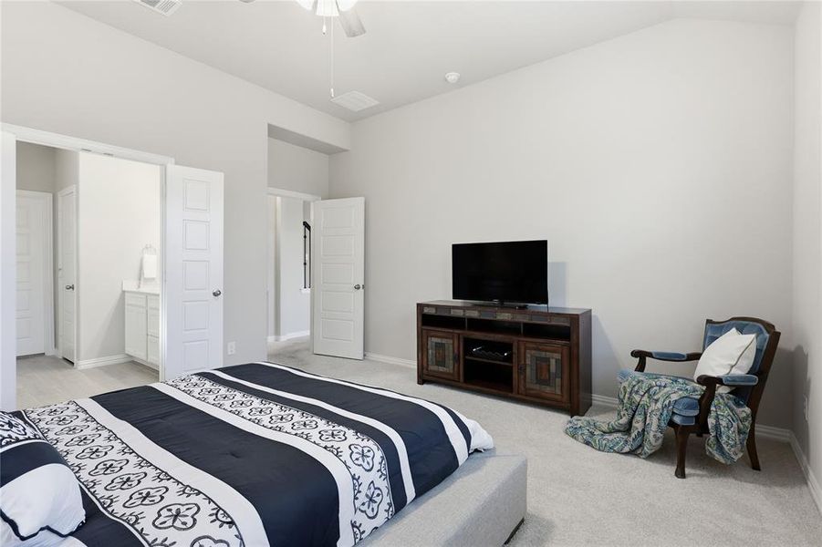 Carpeted bedroom with a vaulted ceiling, ceiling fan, and painted white walls
