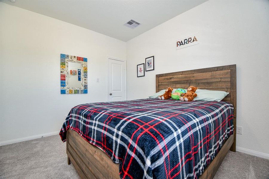 Guests will feel right at home in this spacious bedroom. This spacious bedroom offers plush carpet, neutral paint, a large closet and easy access to a full bathroom.