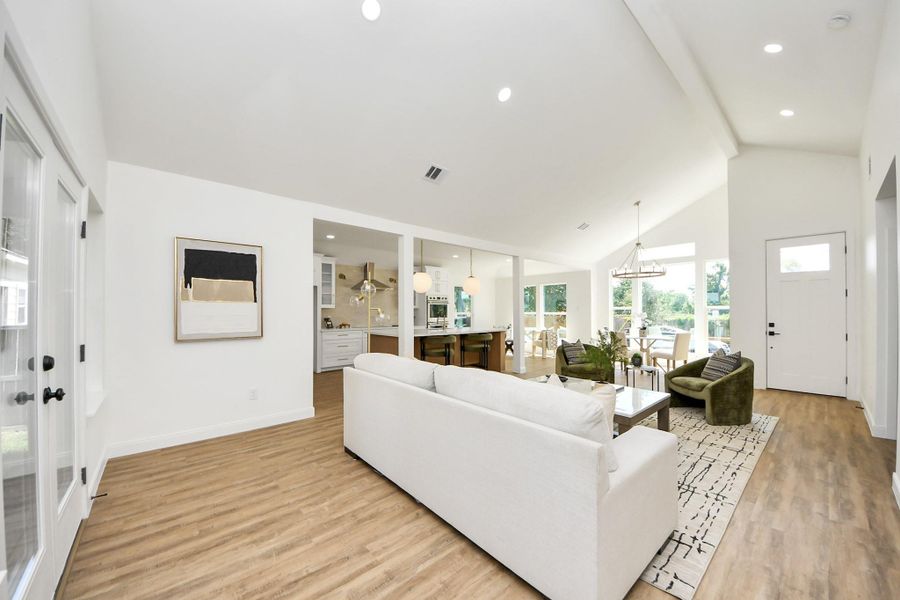 An open, light-filled space where high ceilings and modern lighting create a sense of ease and elegance. Thoughtfully furnished with cozy seating and a dining area that feels both stylish and relaxed—perfect for everyday living or effortless entertaining.