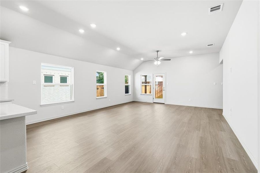 Unfurnished living room with recessed lighting, light wood-type flooring, vaulted ceiling, and ceiling fan