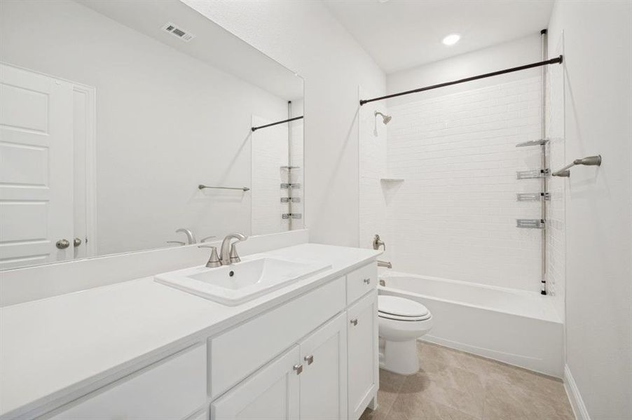 Bathroom featuring a white vanity with an integrated sink, brushed nickel faucet, and a large wall-mounted mirror