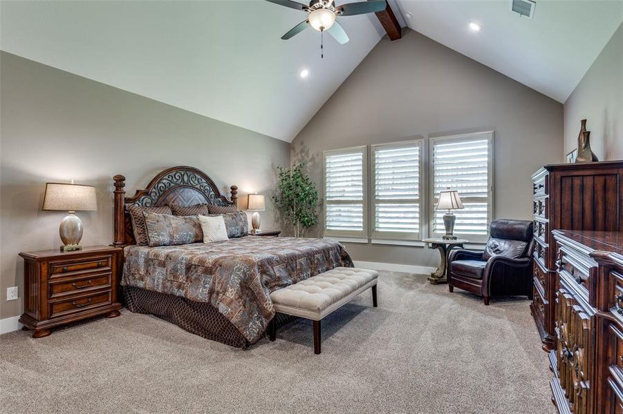 Spacious primary bedroom with cathedral beamed ceiling