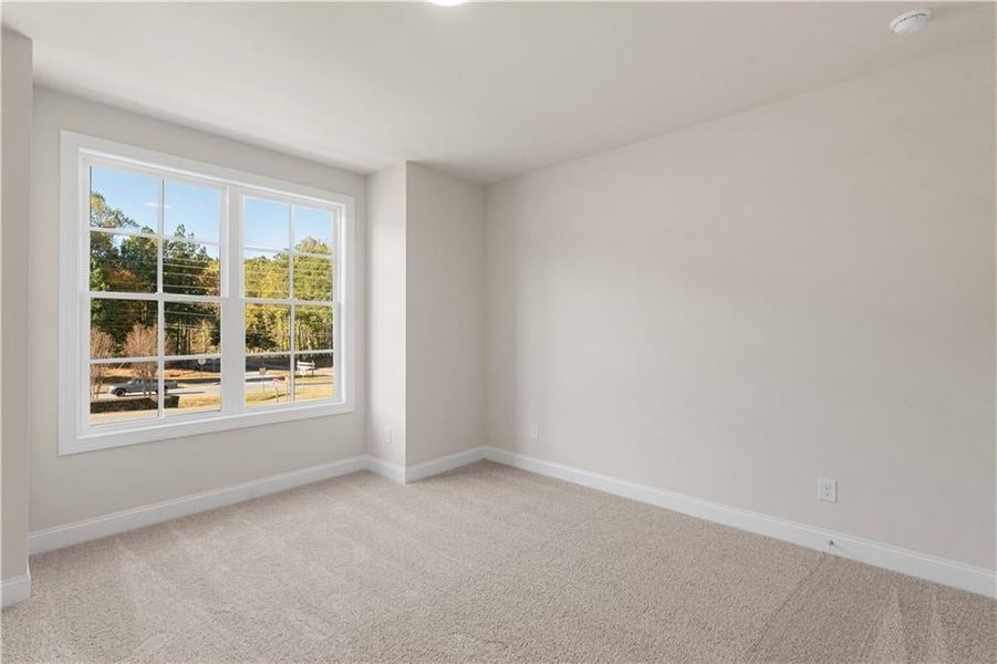 Spare room featuring light carpet and baseboards