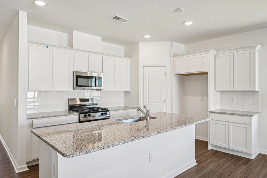 Kitchen - Chic white finishes and smooth surfaces shine.