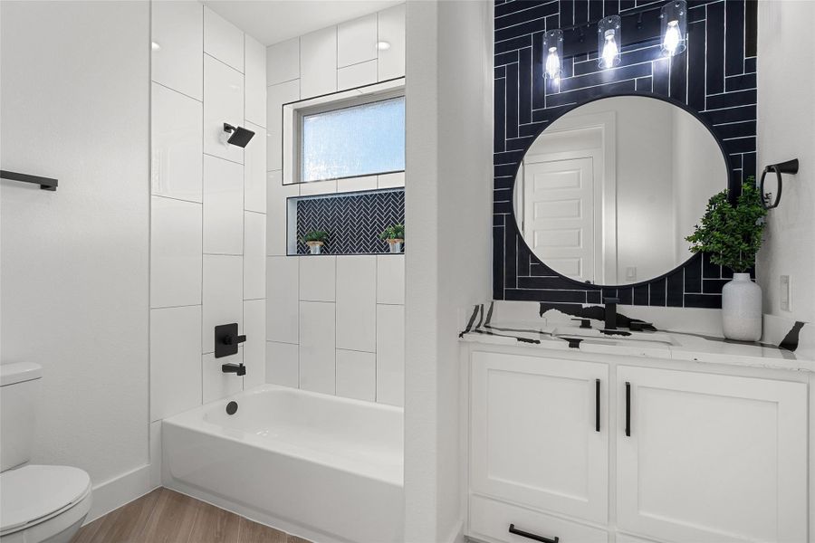Full bath featuring vanity,  shower combination, and light wood finished floors