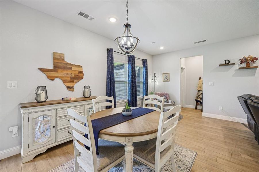 Dining room featuring light wood-style floors, recessed lighting, and a chandelier Dining room featuring light wood-style floors, recessed lighting, and a chandelier