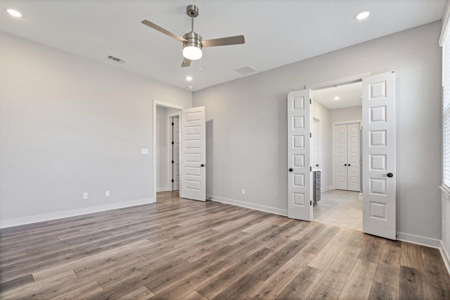 Spacious room featuring wood-finish flooring, recessed lighting, and a ceiling fan
