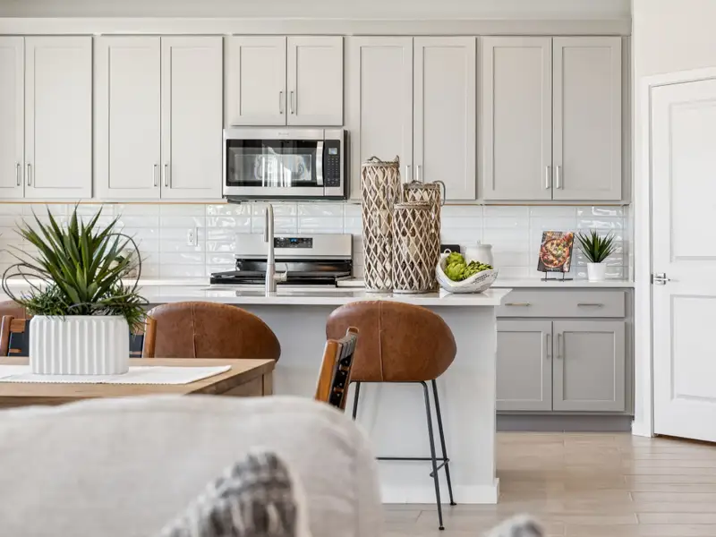 A kitchen with white cabinets.