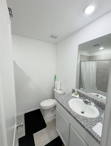 Full bathroom featuring vanity, a shower with curtain, and a textured ceiling