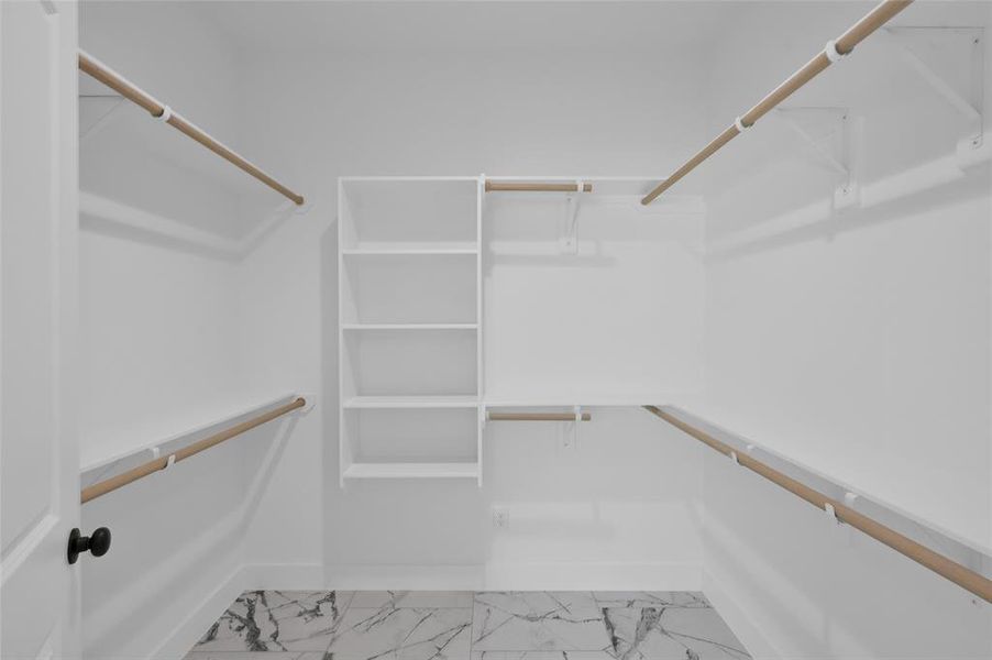 Nice-sized primary closet with porcelain flooring