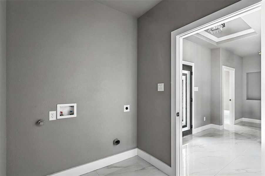 Washroom with hookup for an electric dryer, light marble finish flooring, and hookup for a washing machine Washroom with hookup for an electric dryer, light marble finish flooring, and hookup for a washing machine