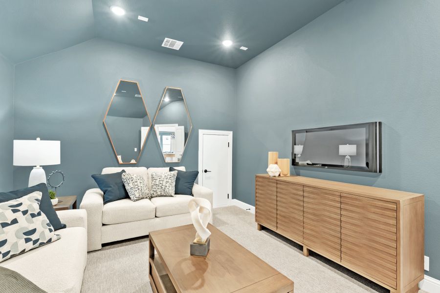 Living room with blue-gray walls, vaulted ceiling, white sofas, wood credenza, and wall-mounted TV Living room with blue-gray walls, vaulted ceiling, white sofas, wood credenza, and wall-mounted TV