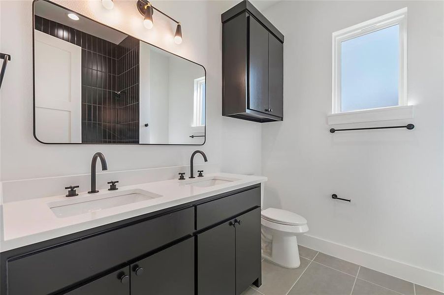 Bathroom with vanity, a shower, toilet, and tile patterned floors