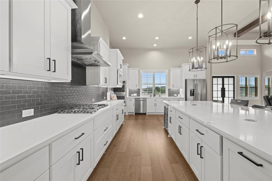 An airy culinary haven boasts white cabinetry, lustrous hardwood floors, and a generously sized island. An airy culinary haven boasts white cabinetry, lustrous hardwood floors, and a generously sized island.