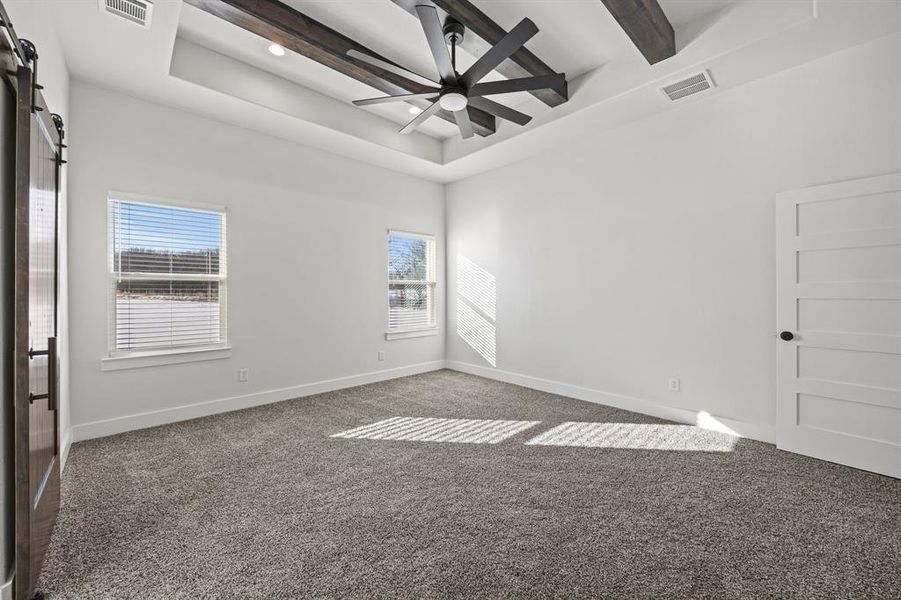 Carpeted empty room featuring a tray ceiling and recessed lighting