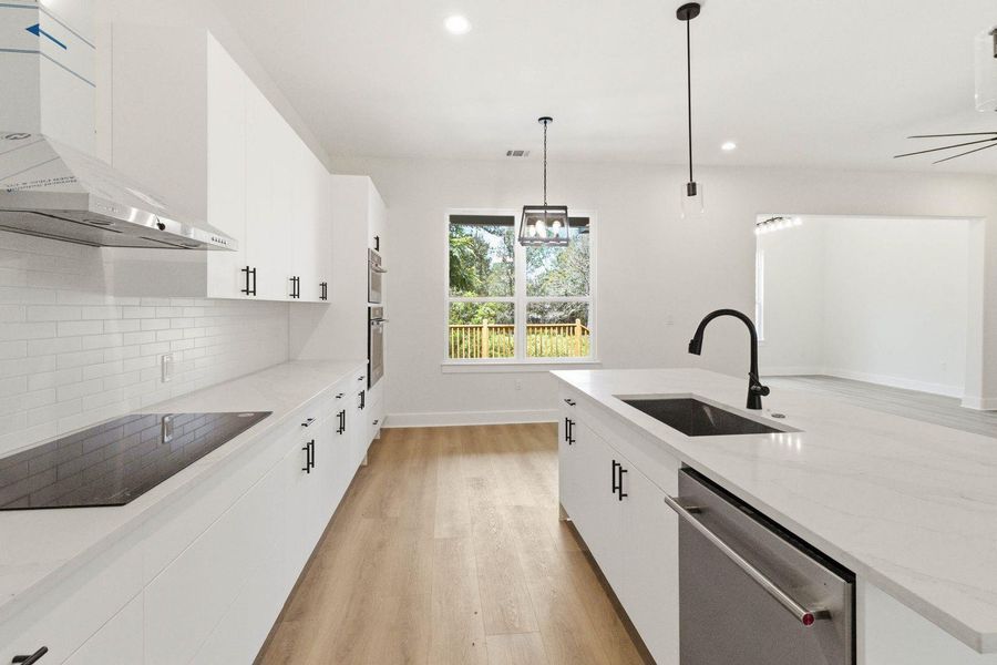 A well-lit culinary space showcases pristine white cabinetry and a generous island, perfect for entertaining. A well-lit culinary space showcases pristine white cabinetry and a generous island, perfect for entertaining.