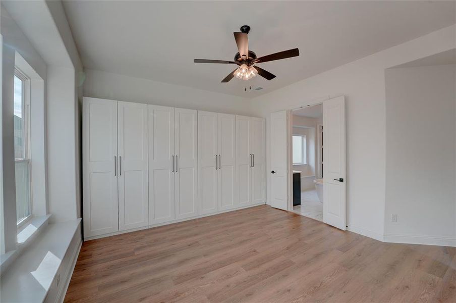 Bedroom with vinyl floors, baseboards, and a ceiling fan