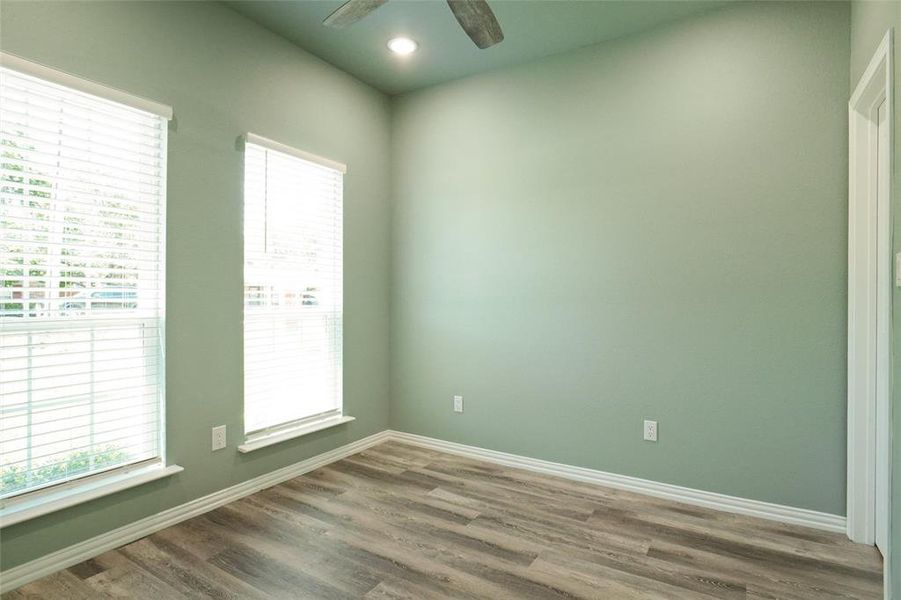 Unfurnished room featuring ceiling fan and dark wood-type flooring