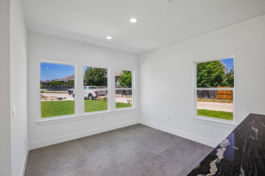 Large windows fill this versatile space with natural light highlighting the stone counters and tile flooring.