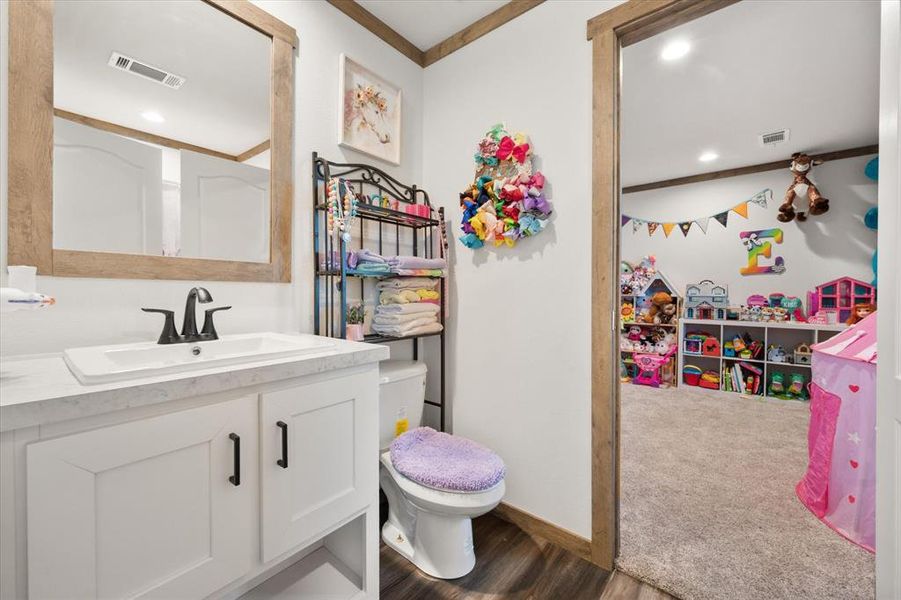 Jack and Jill bath featuring ornamental molding, vanity, dark wood finished floors, and recessed lighting Jack and Jill bath featuring ornamental molding, vanity, dark wood finished floors, and recessed lighting