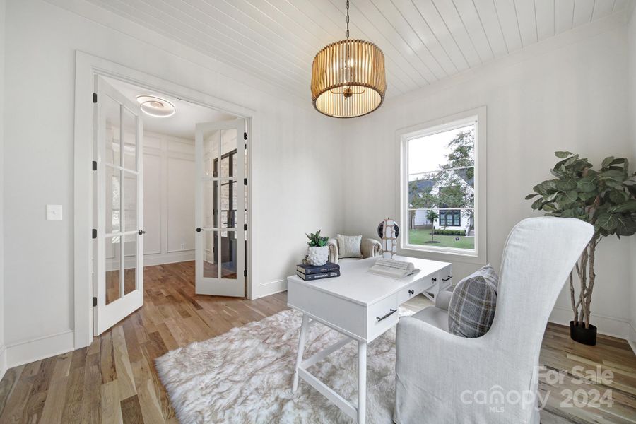 Home office includes french doors and shiplap accented ceilings.