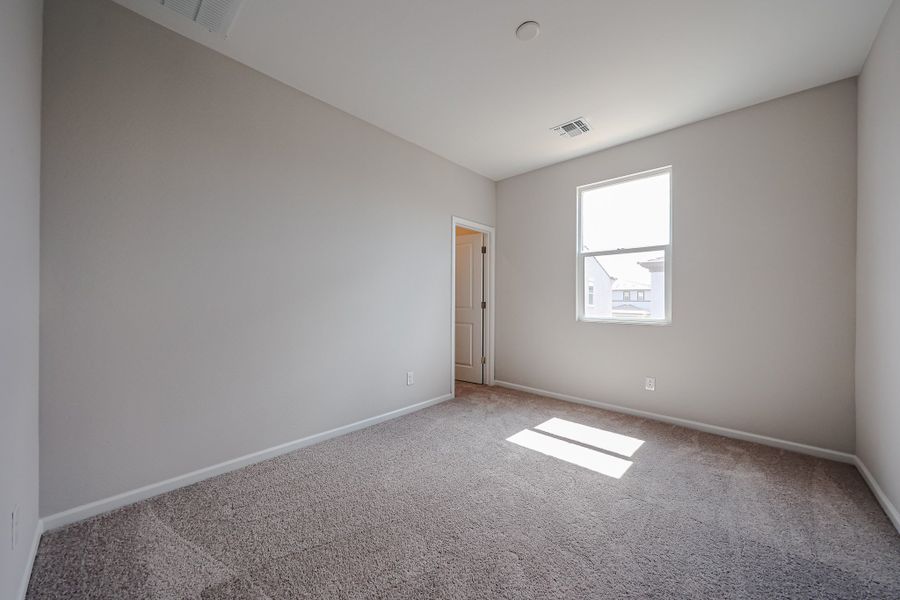 A room with a carpet and a door.