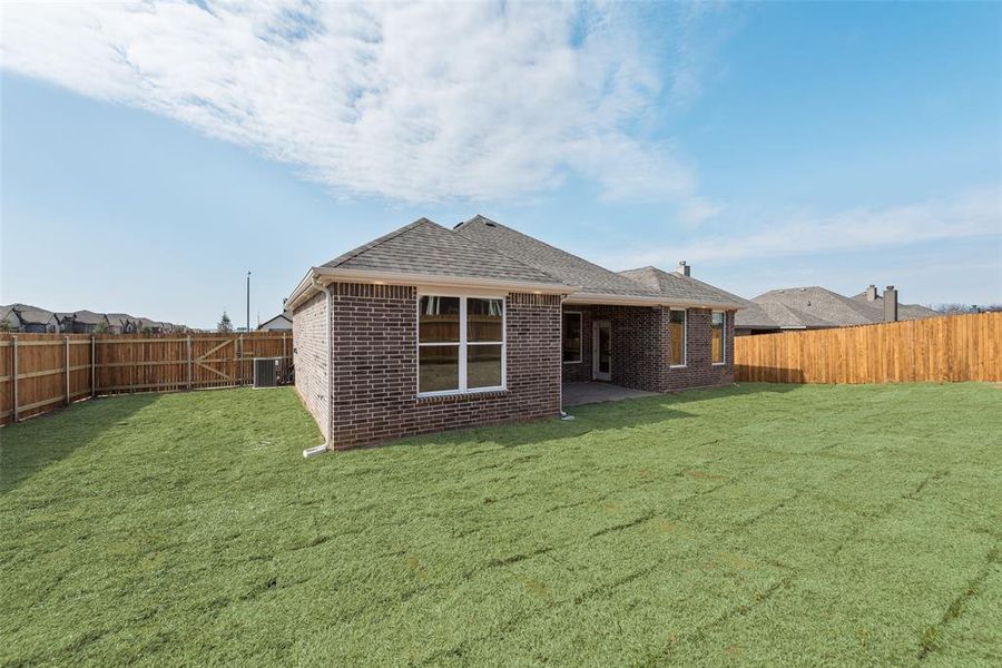 Rear view of house featuring a yard and a patio