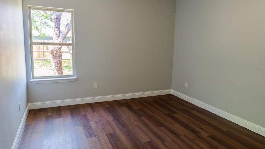 Empty room with dark hardwood / wood-style floors Empty room with dark hardwood / wood-style floors