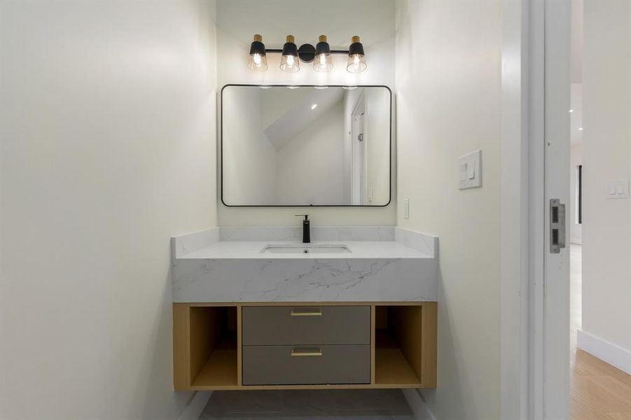 Half bathroom featuring vanity and baseboards